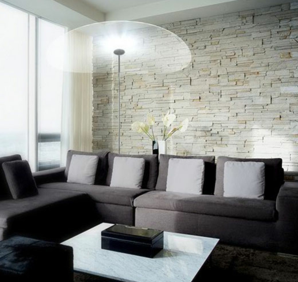 едноетажна тухлена стена с холова гарнитура и диван със сиви възглавници