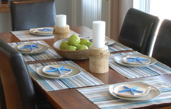 stol za blagovanje s jabukama kao ukrasom - dvije velike bijele svijeće