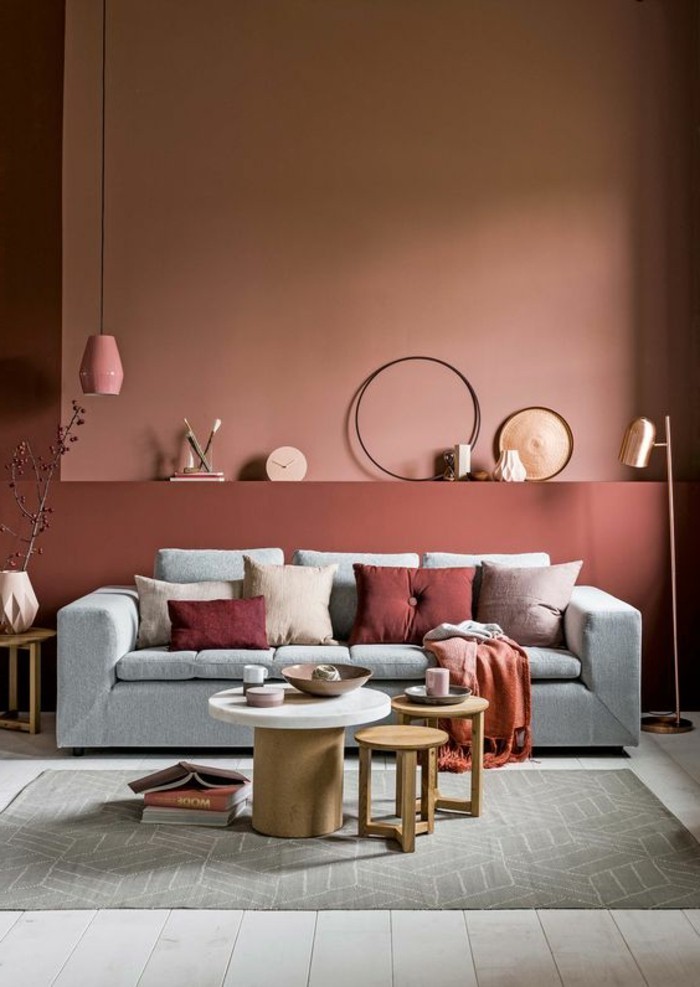 dizajn boje zidovi-opeka-stehlampe-zlato-zid-sat-svijetlo sivo-kauč-okrugli drveni stol uzorak tepiha-Ikebana vaza