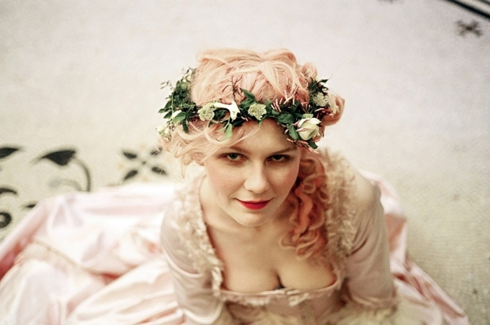Kirsten Dunst középkori frizurával - fehér rózsák virágos koszorúja, rózsaszín haj