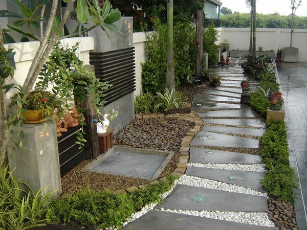 Diseño de jardín con una pasarela hecha de losas de piedra