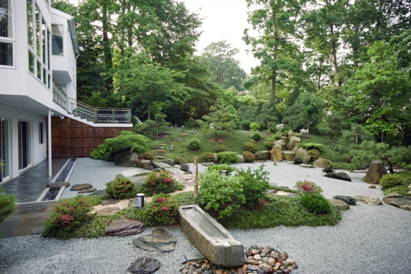 Grand jardin avec des pierres et des plantes vertes pour un design moderne de manoir