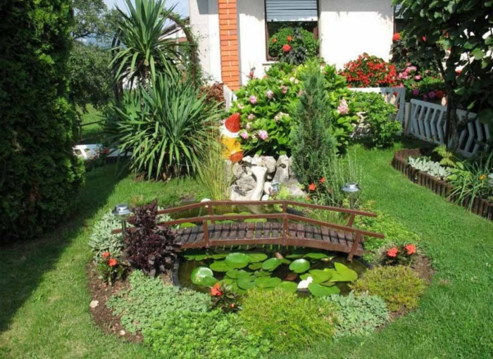 минималистична градина с малки водни лилии и зеленина с мост
