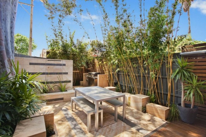 модерен дизайн на градината с мебели за вътрешен двор с високи уединения и високи растения