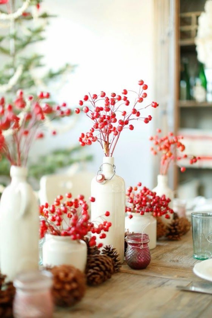 уютна декорация на маса с шишарки и червени цветя