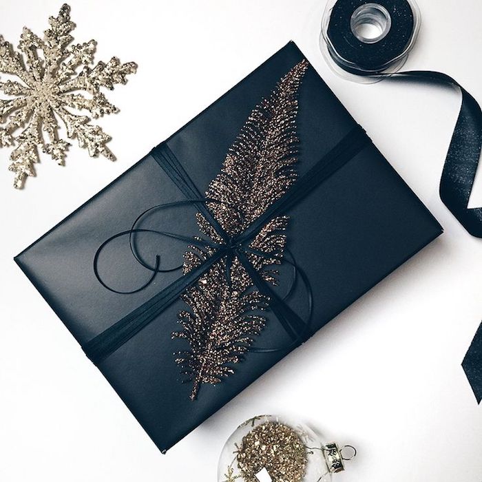 Elegante papel de regalo en color negro, decoración de plumas, bola de Navidad