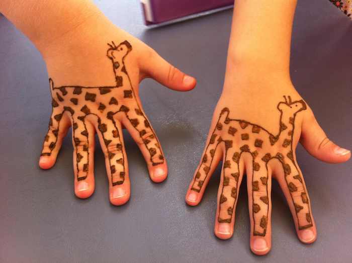 две малки сестри с къна татуировки жирафи на малки ръце