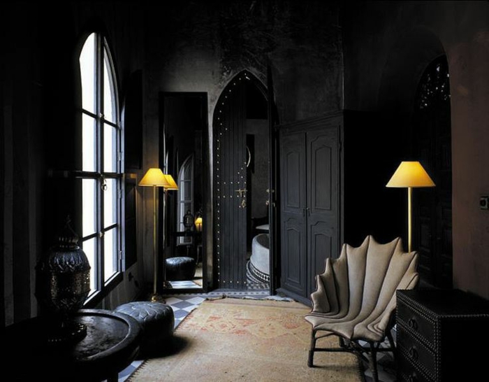 Relaxecke с готически фотьойл, килим в естествени цветове, черни стени, черни скринчета, двуетажни лампи