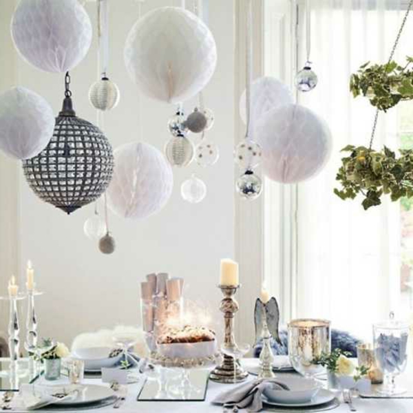 бяла коледна украса - висящи бели топки над масата