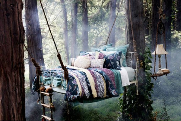 κρεμασμένο κρεβάτι με μαξιλάρι ρίψης - ανάμεσα στα δέντρα στο δάσος