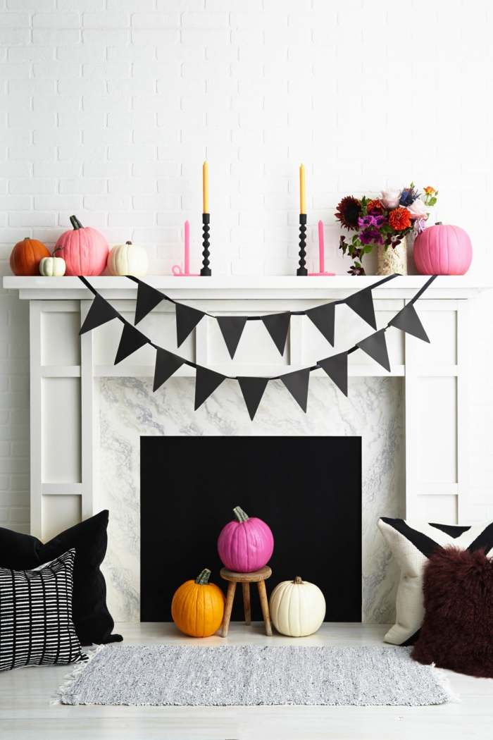 Halloween dekoráció a nappaliban, színes sütőtök, őszi virágok, fekete girlanede