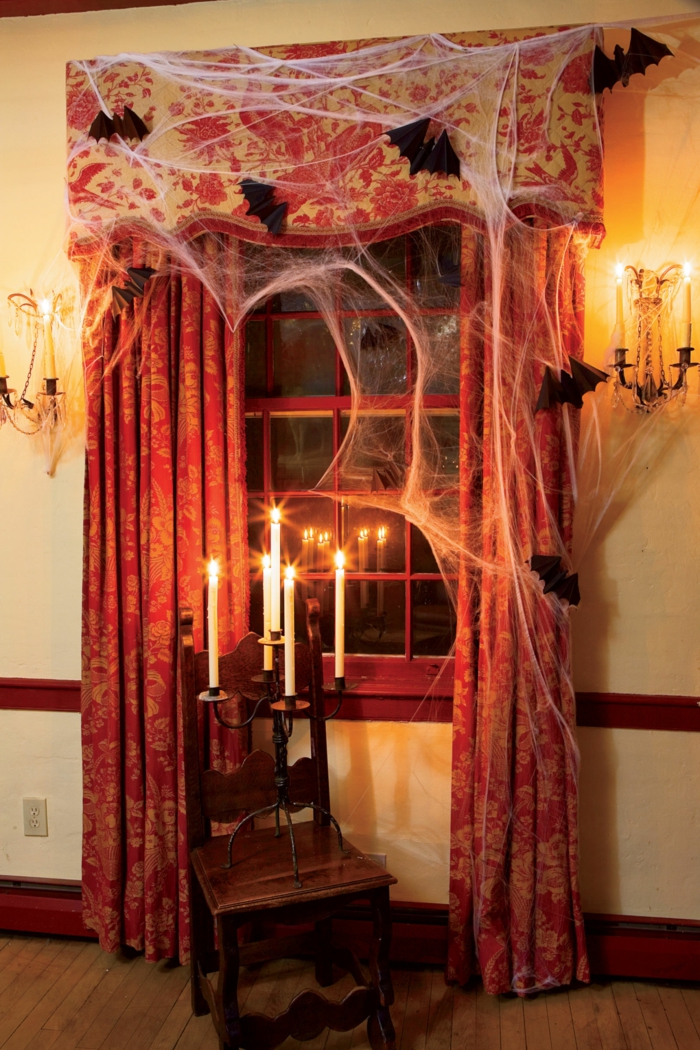 Halloween koristelu, hämähäkinverkko ja lepakoita, kynttilänjalka ikkunasta