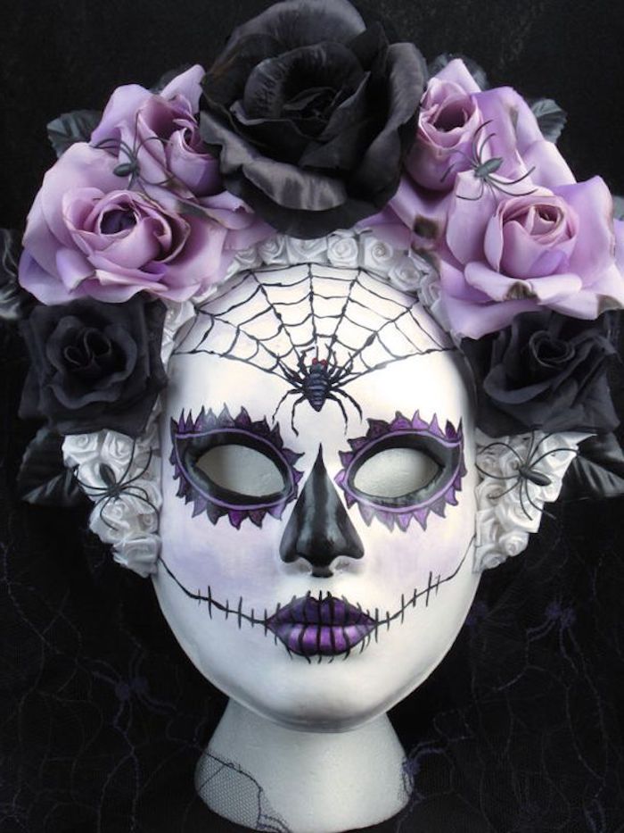 egy lila maszk pókhálóval és lila és fekete virágokkal díszítéssel - kísérteties Halloween maszkok