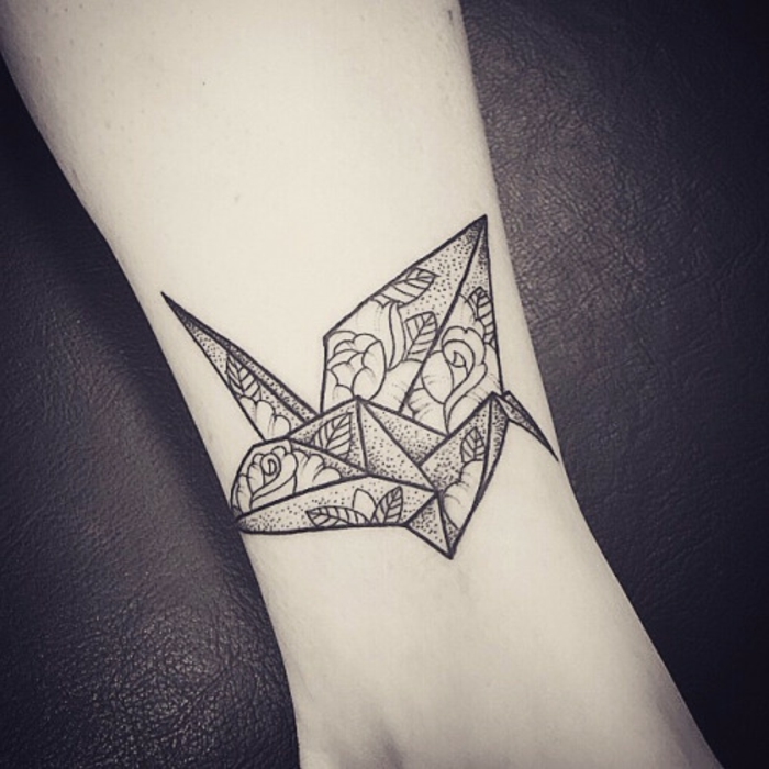 μαύρο λίγο που φέρουν πουλί origami με λευκά λουλούδια - ιδέα για ένα μικρό τατουάζ τατουάζ στο χέρι