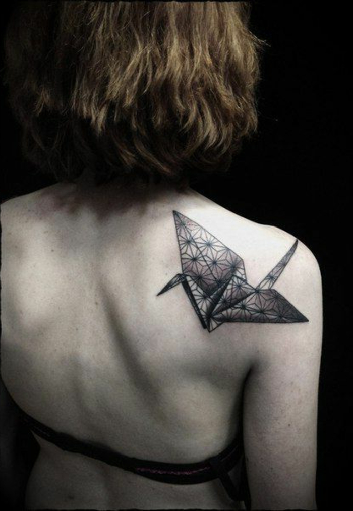 Tekintsd meg ezt az ötletet egy origami tetoválásról - egy kis fekete origami madár egy fiatal nő vállpengére