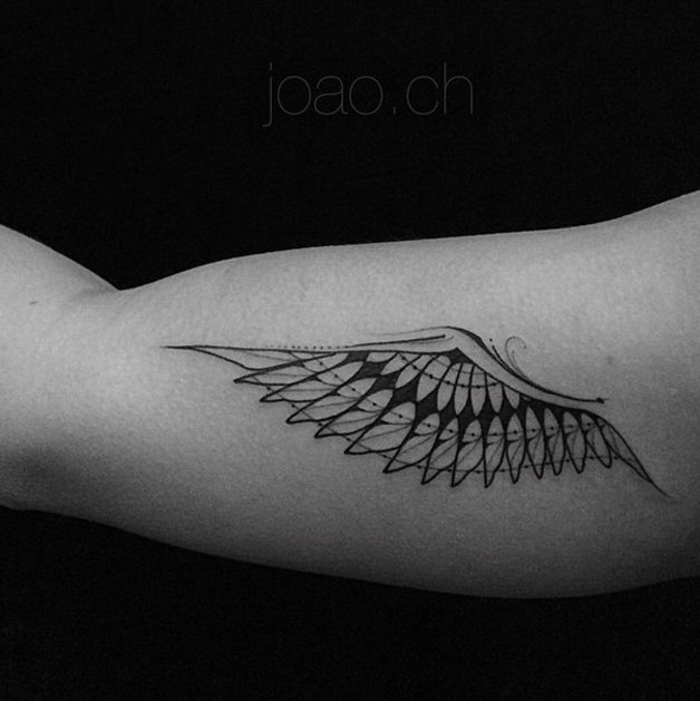 Ruka s malom crnom anđelovom tetoviranom krilom s dugim crnim perjem