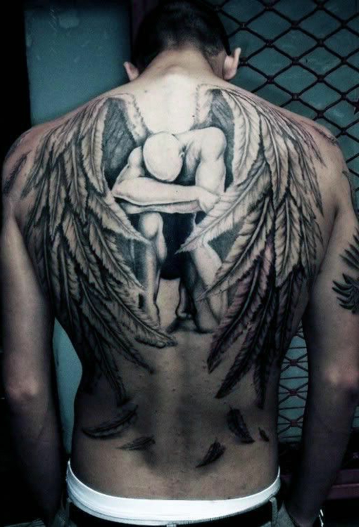 surullinen, itkevä enkeli, jossa on suuret valkoiset siivet, joissa on pitkät höyhenet - toinen idea kivaa enkeli siiven tatuoinnille, jota miehet voivat todella pitää