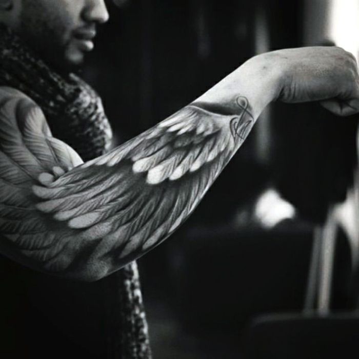 toinen mies, jolla on kaunis musta tatuointi - tässä on enkeli tatuointi, jossa on enkelin siivet valkoisilla höyhenillä
