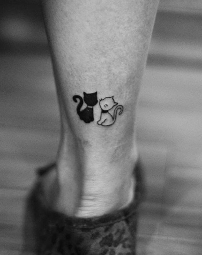 toinen ideoistamme kissojen tatuoinnilla jalalla - musta kissa ja pieni valkoinen kissa, jossa on mustat värähtelyt
