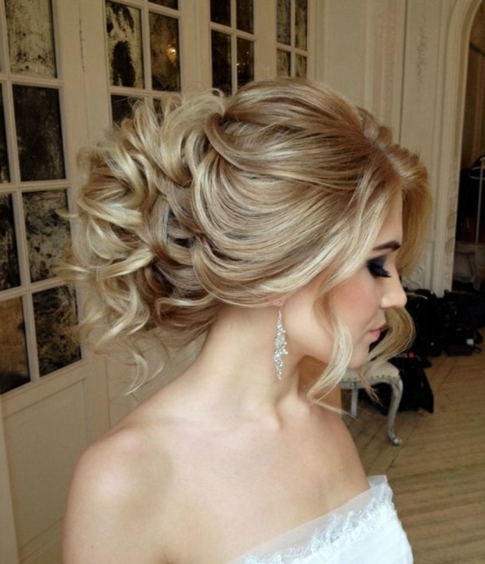 hölgy egy romantikus menyasszonyi frizurával és egy gyönyörű sminkkel