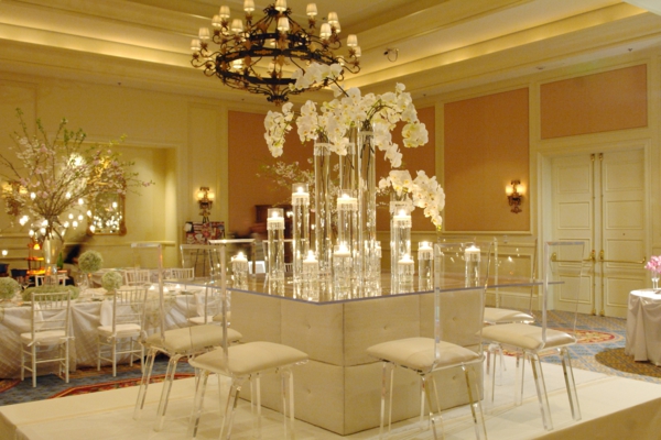 esküvői asztal dekoráció - szuper elegáns fehér székek és virágok egy nagy csillár alatt