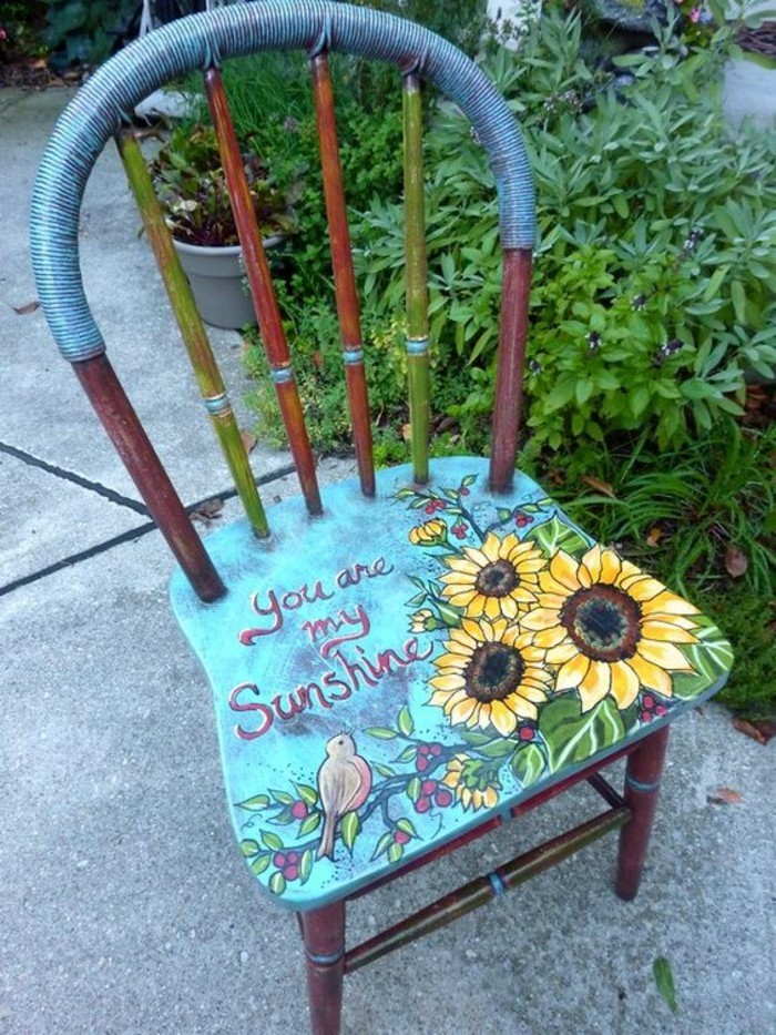 كرسي خشبي، عمره في الزرقاء الطلاء-الزهور الصفراء grpnen-النبات الطيور صورة