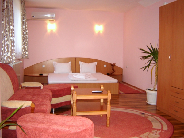 zanimljiva soba s ružičastim krevetom u boji s bijelim pokrivačem