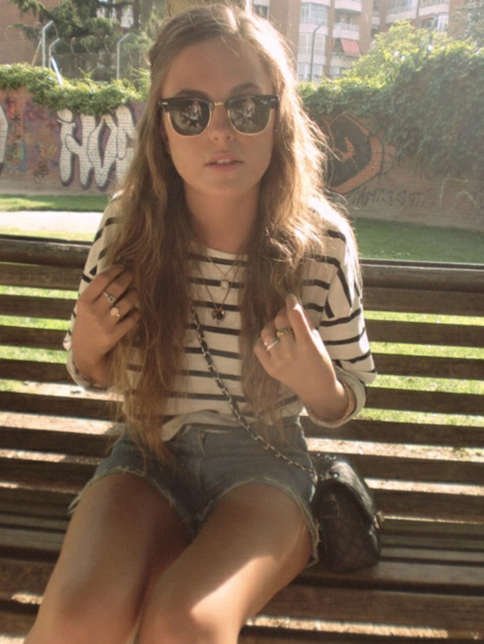 Nuori tyttö pusero Strip lyhyt denimihousuja Chanelin laukku Hipster lasit mukava muoto