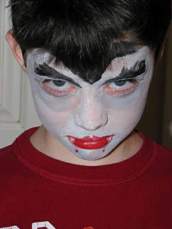 παιδί βαμπίρ αντιμετωπίζουν τα χείλη μακιγιάζ με κόκκινο χρώμα
