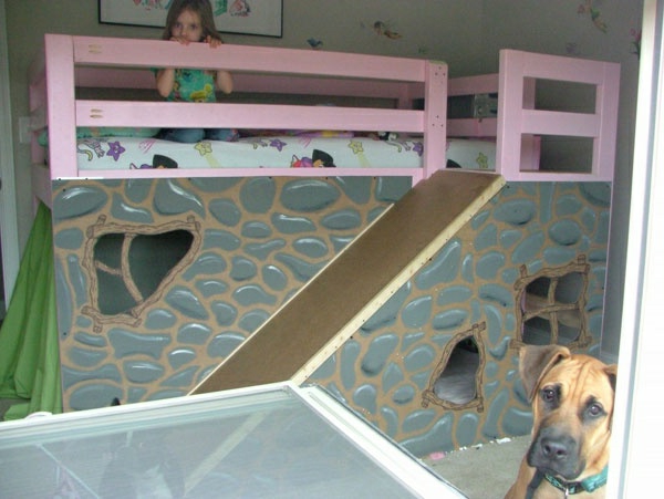 habitación para niños con una niña y una cama alta con tobogán