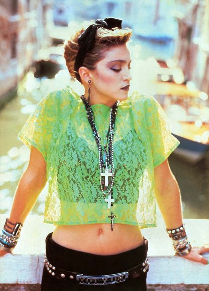 Мадона през 80-те със зелена блуза с тюл, черна коса, черни панталони и много гривни