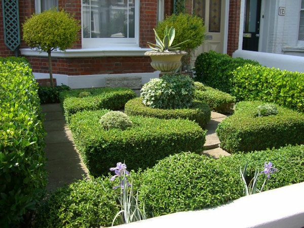 красива къща с градина - зелени растения и скулптурен камък