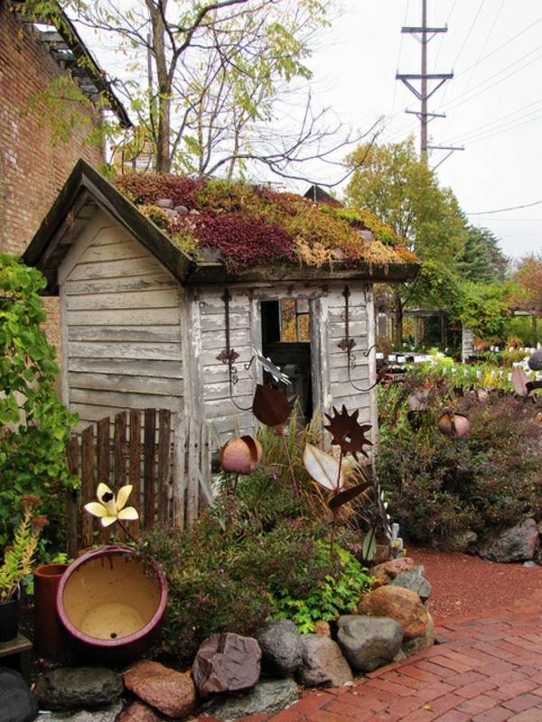 imagen del jardín con piedras - pequeña casa de madera