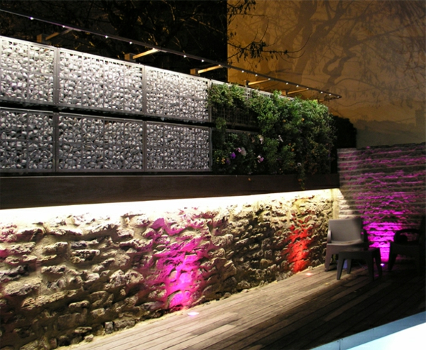 الجدار الحجري المصمم بشكل خلاق مع إضاءة مثيرة للاهتمام