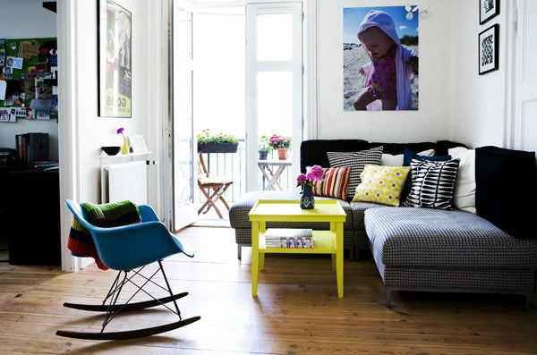 Salon design avec un canapé, une table en jaune et une chaise de balançoire