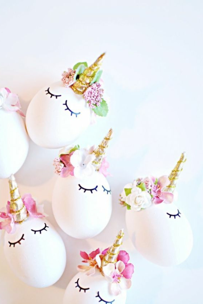бели яйца смешни като еднорози със златни рога и цветя за украса