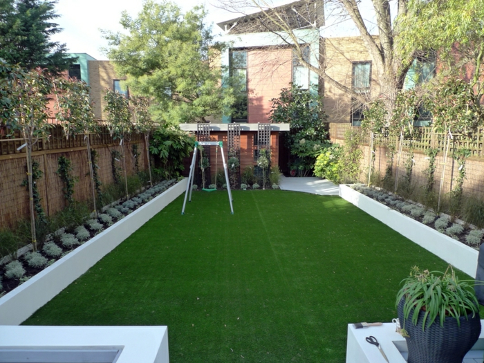 два симетрични редици от растения на оградата, зелена тревна площ - модерен предстен двор