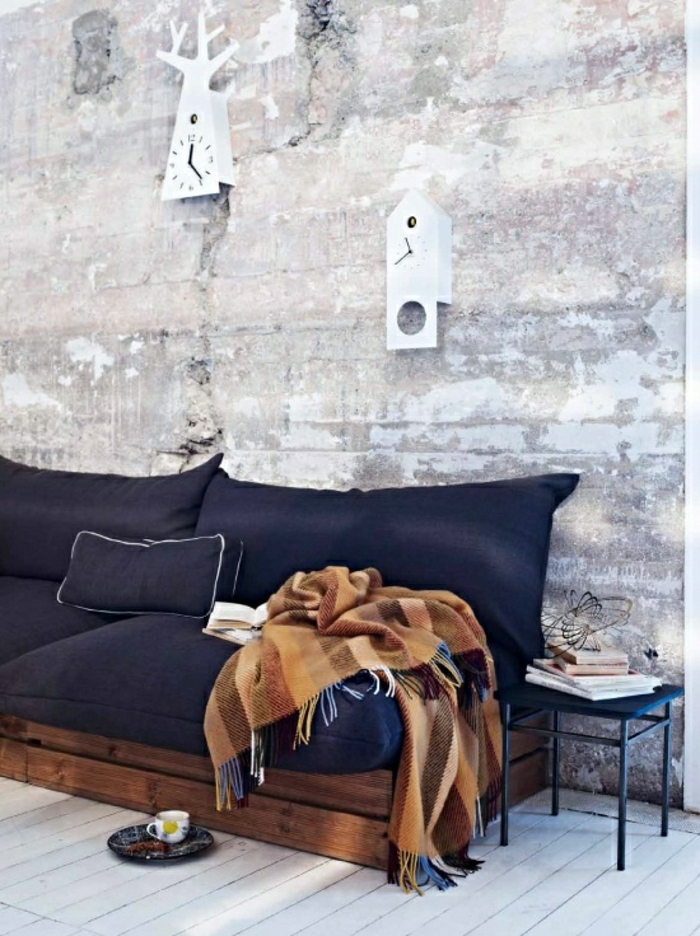 minimalistički interijer-prostorno-sobni palete Kauč plave-presvučena vintage deka zidni satovi-opeke zidovi