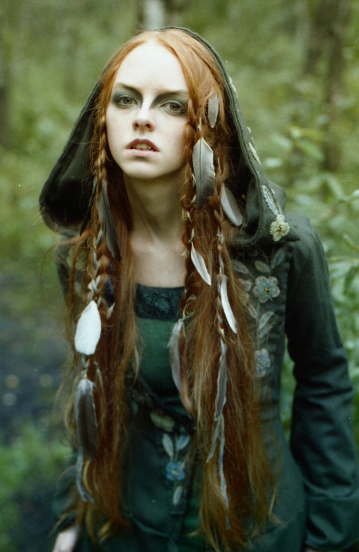 вещица в гората с пера в косата си червена коса, зелена рокля - средновековна прическа
