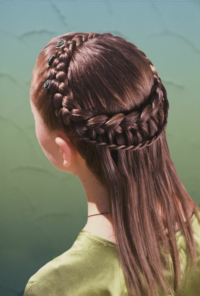 деликатна прическа за момиче от средновековна кафява коса със зелени цветя като принадлежност за коса