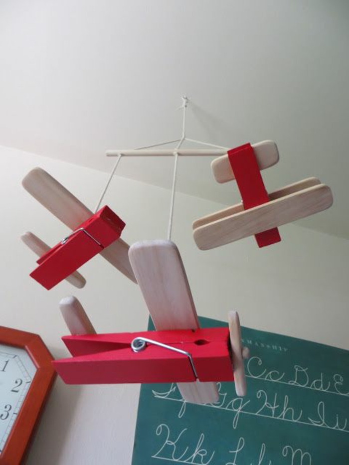 Avión móvil hecho de soportes de madera en color rojo
