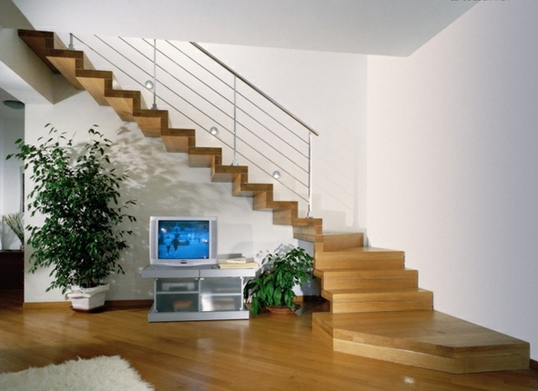 escalier flottant dans le salon avec des plantes vertes et une télévision