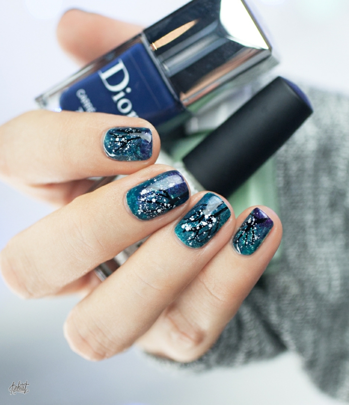 Idée pour les ongles d'hiver, les arbres d'hiver sur un fond bleu, la forme de l'ongle ovale, les ongles de Noël pour re-style