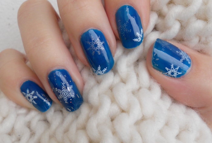 Flocons de neige blancs et argentés sur fond bleu foncé, forme d'ongle ronde, conception d'art d'ongle d'hiver