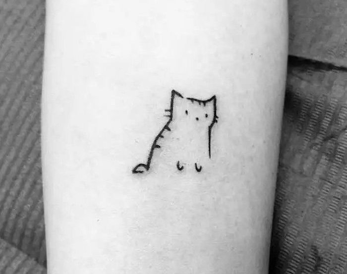 egy kézzel egy kis fekete macska tetoválás - itt egy macska, fekete szemű és vibrissen