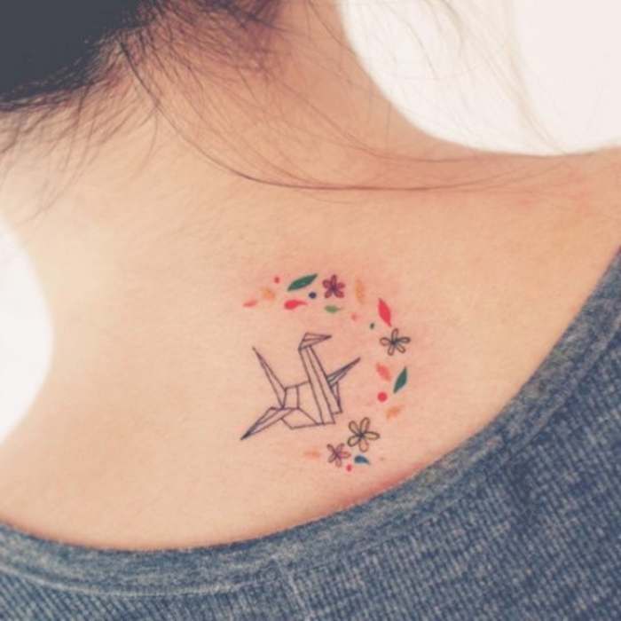 hieno idea pienelle origami-tatuoinnille nuoren naisen kaulaan - tässä on lentävä origami-lintu ja monet pienet kukat