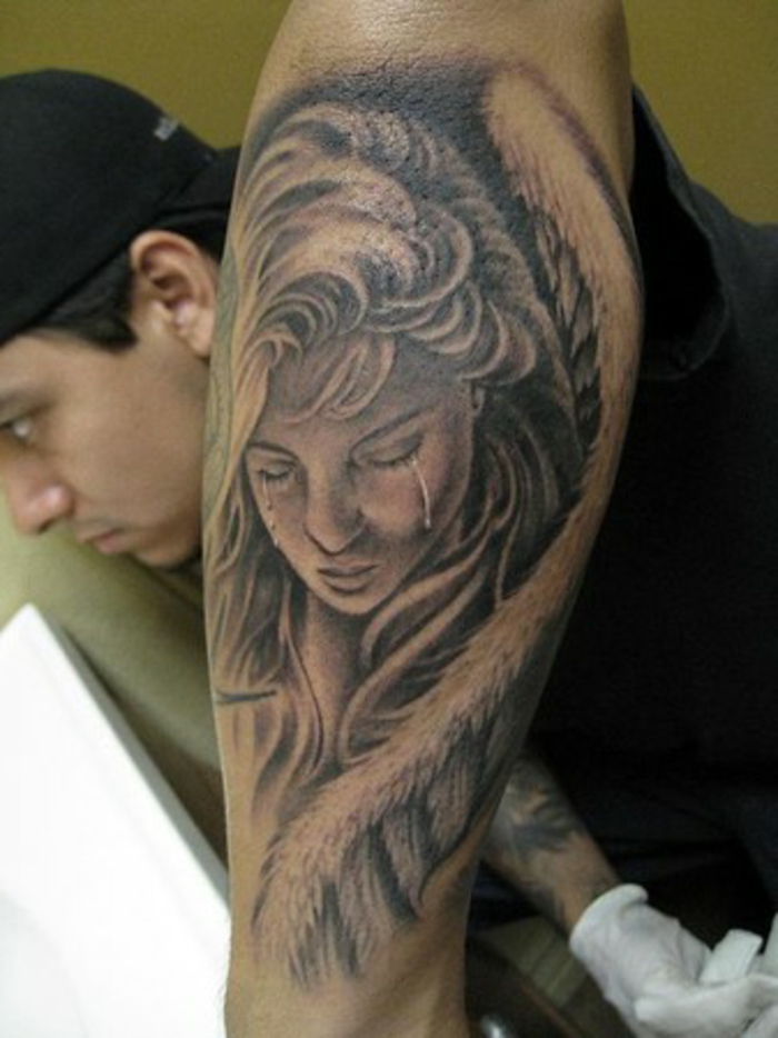 egy szomorú és síró nő, nagy angyalszárnyú fehér tollal - ötlet egy tetováló angyal számára a férfiak számára