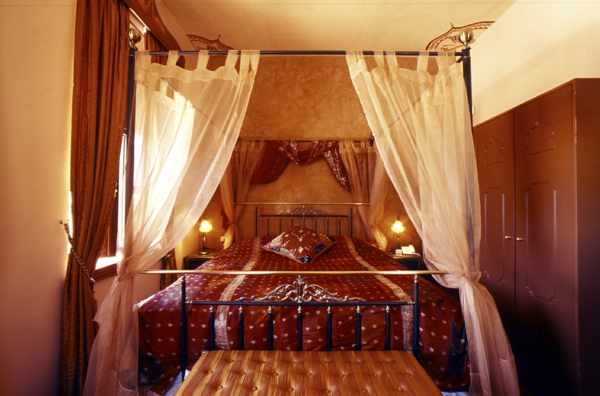 Makuuhuone ruskeilla väreillä ja valkoisilla verhoilla korostettuna - itämainen tyyli