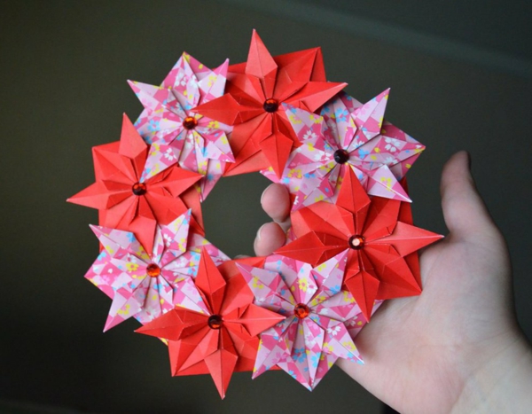 origami-a-karácsony-koszorú-a-virágok - a kézben - fotó felülről