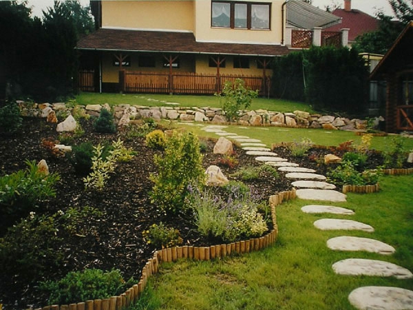 Steinplatten μονοπάτι και πράσινα φυτά στον πανέμορφο κήπο ενός άνετου σπιτιού